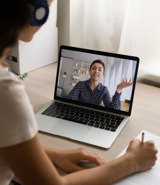 Indian woman participate in videoconference, laptop screen view over female shoulder. Businesswomen negotiating remotely, tutoring and online counselling, e-study process via video call event concept